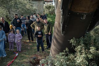 Palestinians gather around the remnants of an Iranian missile that landed in the Palestinian village of Hares in the Israeli-occupied West Bank on March 24, 2026